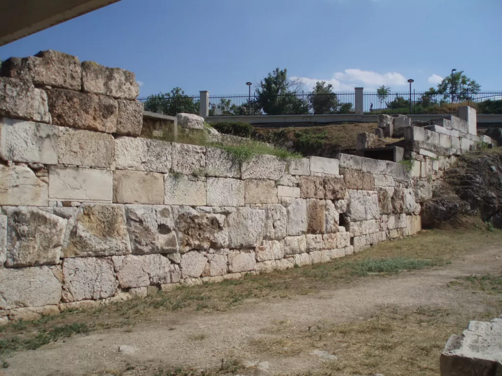 Low stone foundations of Athens’ Long Walls running toward the harbour