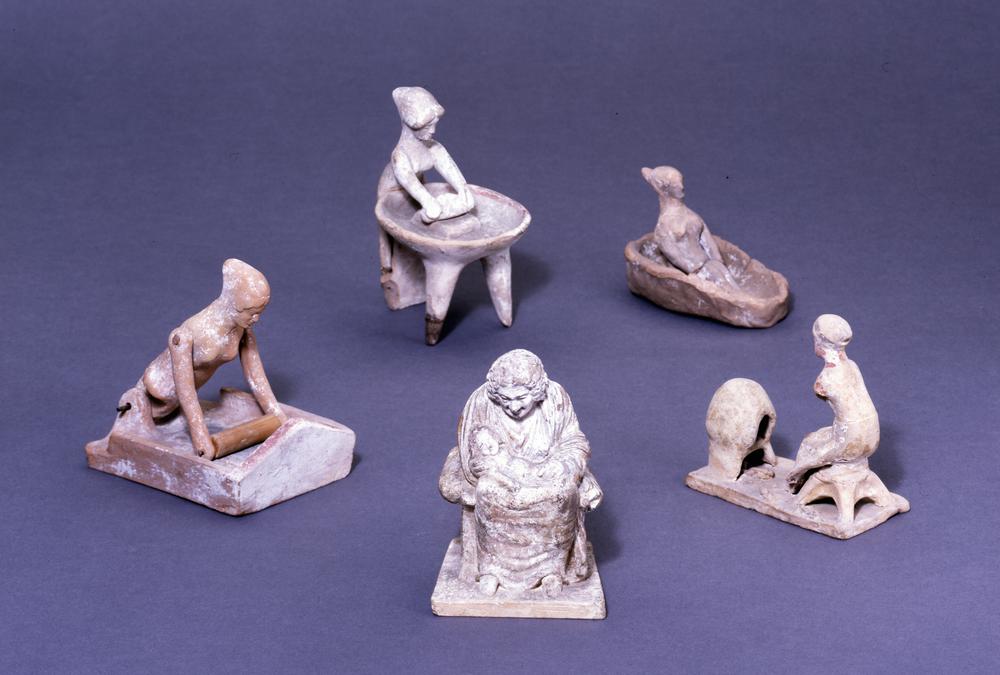 Hellenistic terracotta figure of an enslaved men kneeling at a rotary quern