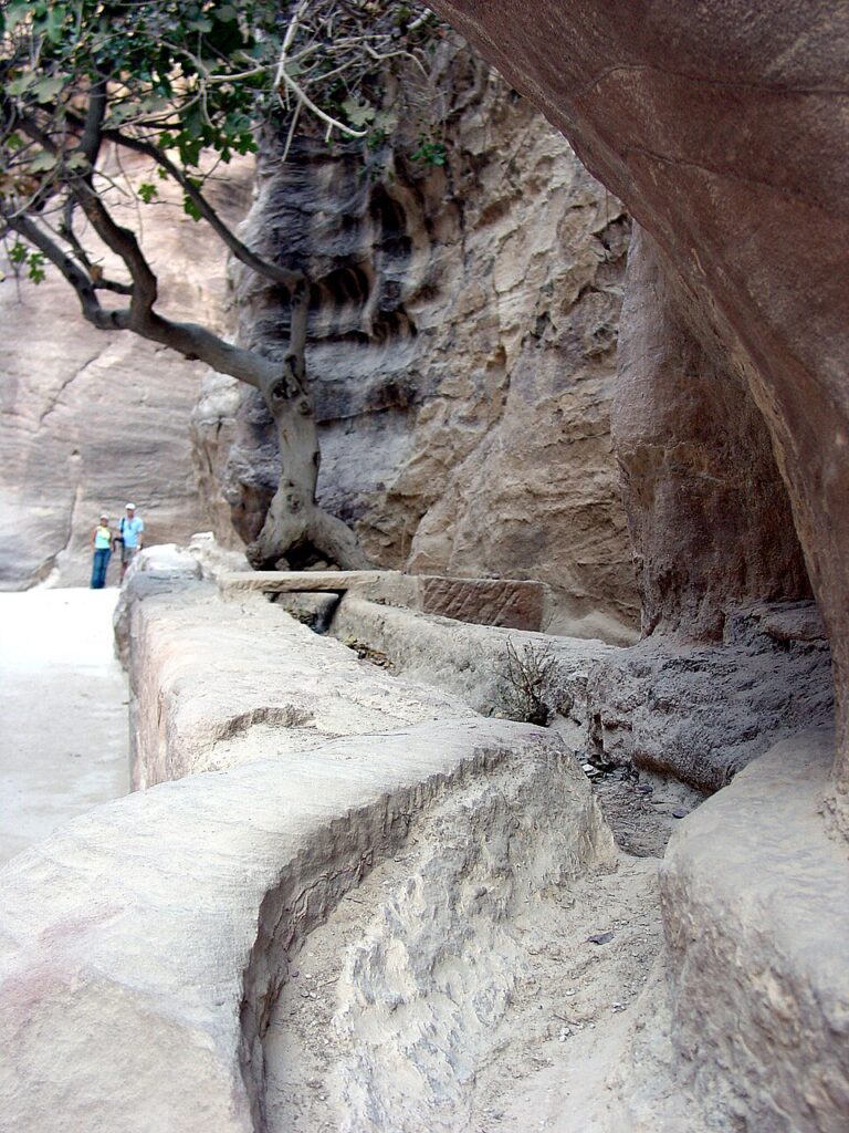 Ancient Infrastructure in Petra with rock-cut gutters lining the Siq approach