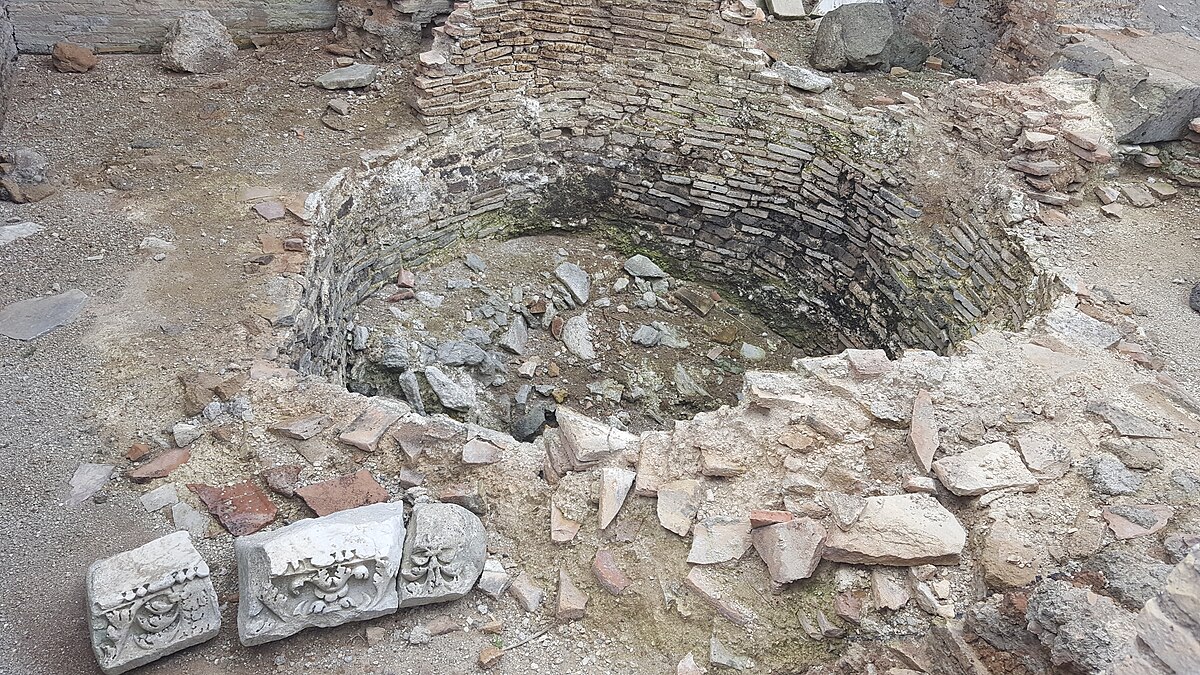 Masonry lime kiln built into a slope with firing chamber.